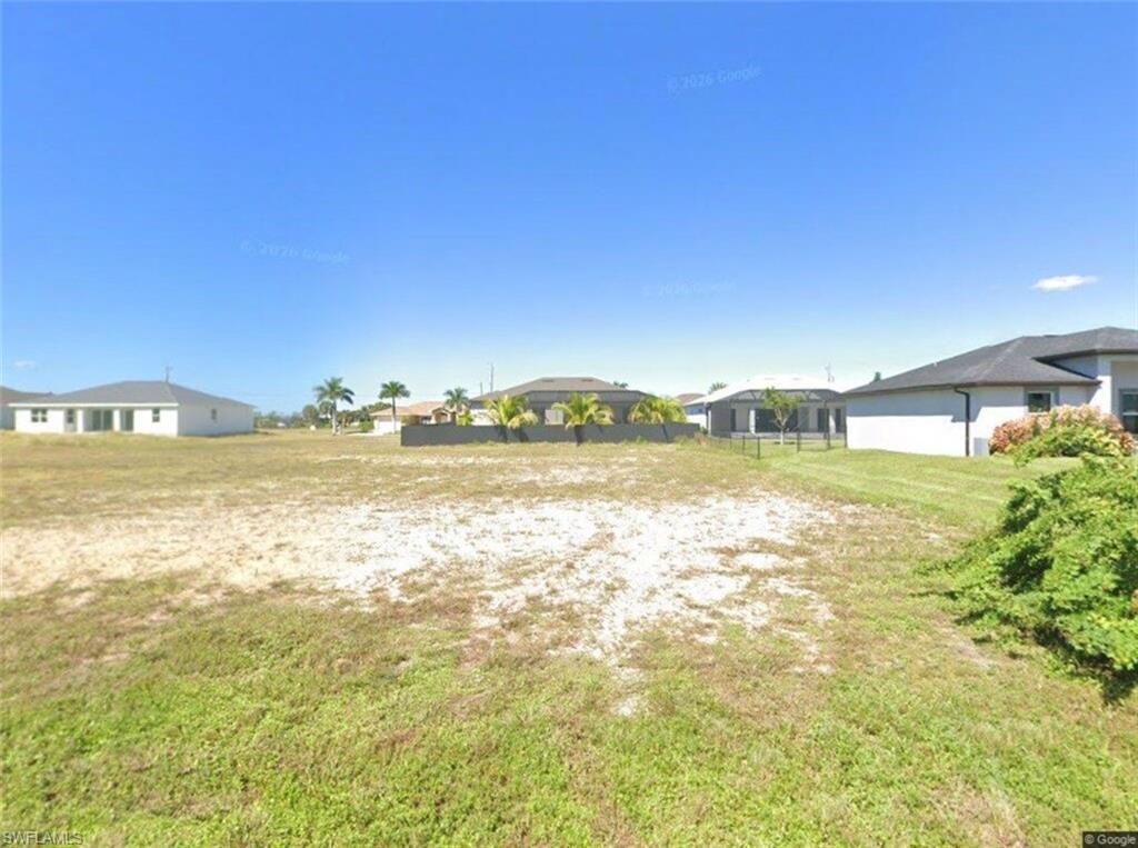 Image 1: Expansive lot featuring a mix of cleared land and natural ground cover