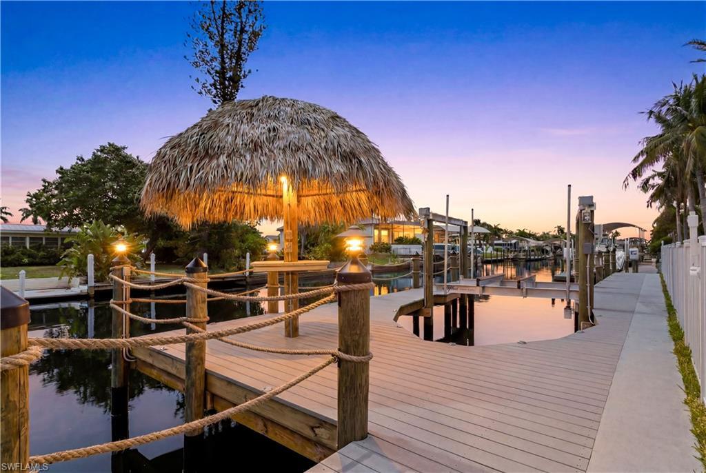 Image 4: Enjoy 80 ft of COLONY CANAL frontage, CAPTAIN'S WALK, 10,000-lb BOAT LIFT, TIKI HUT & FULLY EQUIPPED DOCK