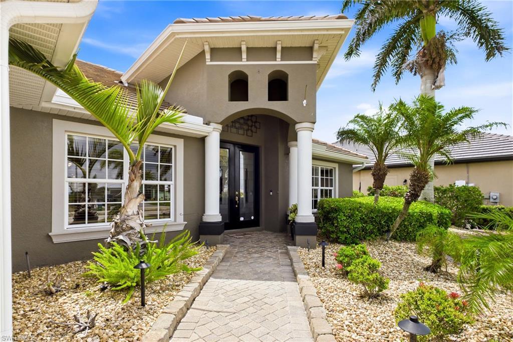 Image 2: Modern Mediterranean-style facade featuring a prominent arched entryway with double glass doors