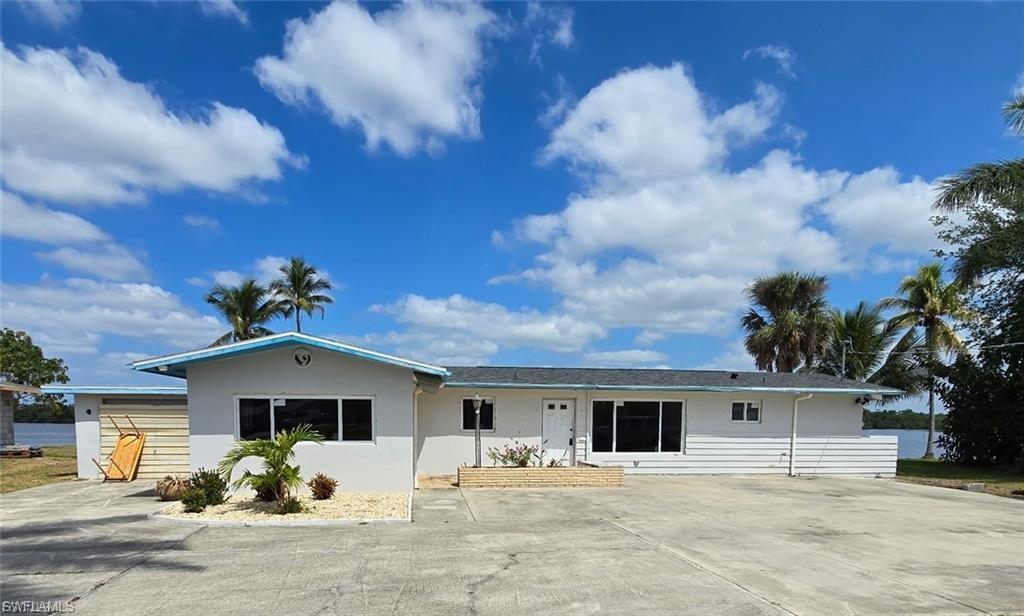 Image 1: White exterior residence featuring a black shingle roof and contrasting light blue trim