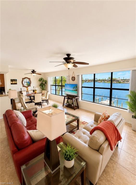 Image 3: Open-concept living space featuring expansive windows, water views, and tile flooring