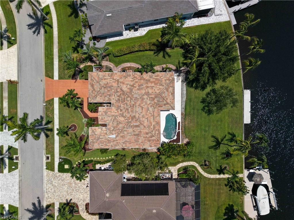 Image 1: Property featuring a tile roof, a private swimming pool, and a waterfront location with a boat dock