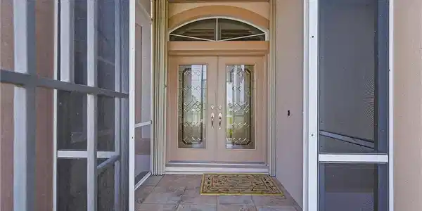 Image 4: Double entry doors with decorative glass panels and an arched transom window