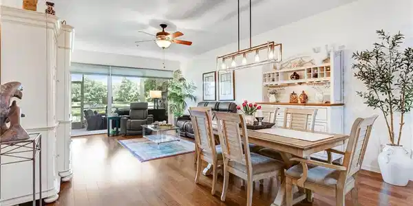 Image 2: Hardwood-finish flooring throughout, built-in shelving with integrated wine storage, ceiling fan, and linear chandelier