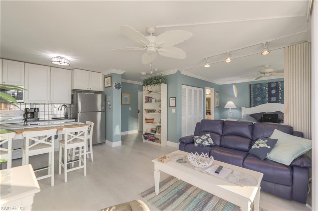 Image 2: Living room with ceiling fan, rail lighting, sink, and ornamental molding
