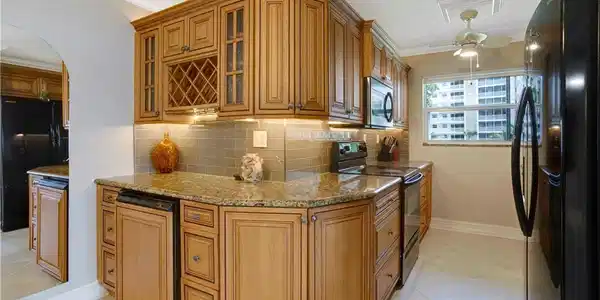 Image 3: Reconfigured kitchen with wine rack, glass cabinet doors, glass subway tile.