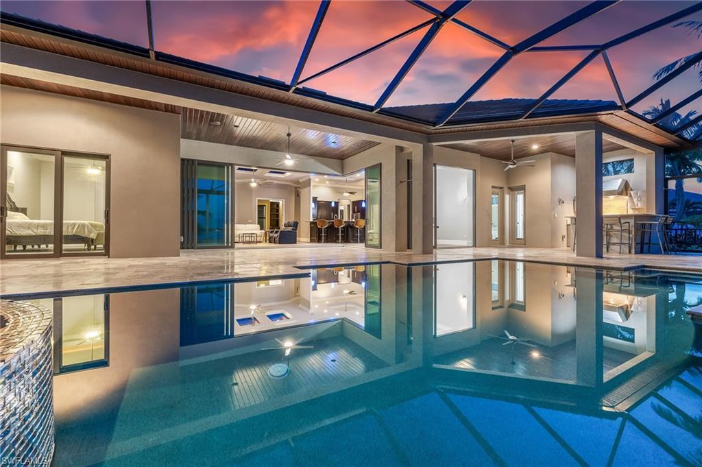 Image 4: Pool at dusk featuring a ceiling fan, a patio, a lanai, and a pool