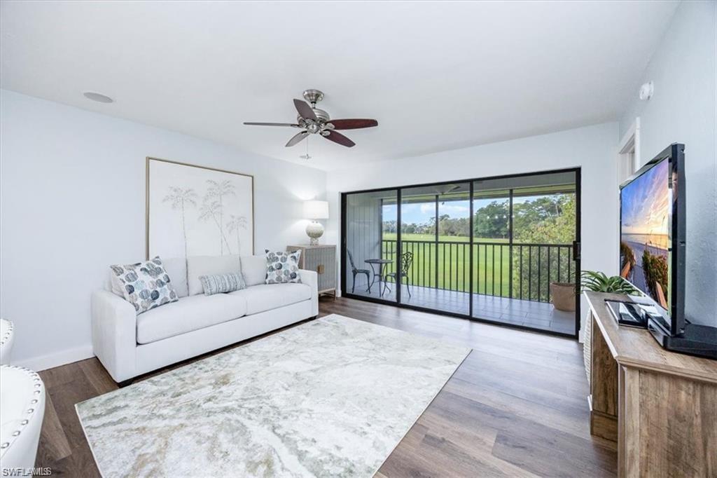 Image 3: Living area with wood finished floors and a ceiling fan