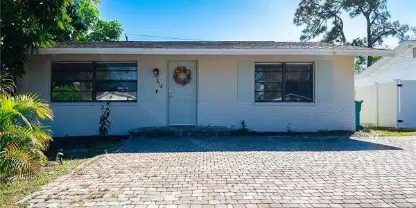 Image 2: View of front of home with brick siding and stucco siding