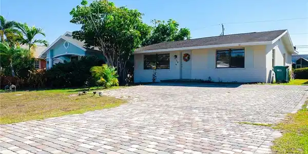 Image 3: View of front facade featuring brick siding and a front lawn