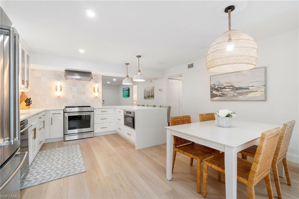 Image 3: Kitchen featuring pendant lighting, a peninsula, white cabinets, and light stone counters