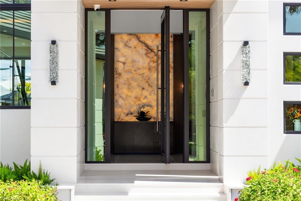 Image 2: View of exterior entry with stone siding and stucco siding