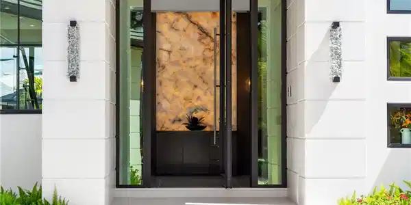 Image 2: View of exterior entry with stone siding and stucco siding