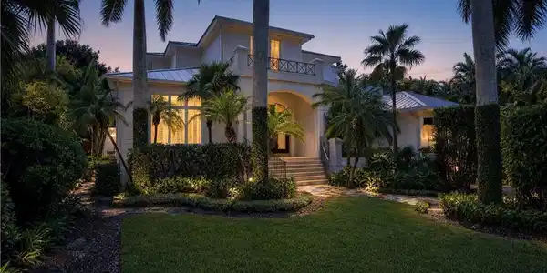 Image 3: Stucco exterior with a tiled roof, elevated entry, and a second-story balcony