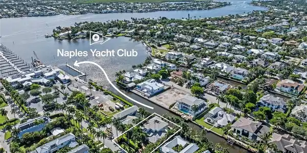 Image 4: Aerial perspective showcasing a waterfront community with numerous residential properties, surrounding waterways, and the Naples Yacht Club