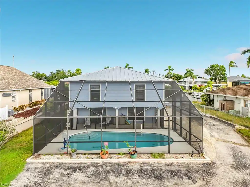 Image 1: Screened-in pool deck featuring an irregular-shaped pool