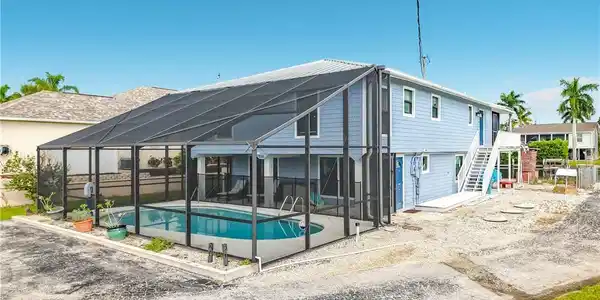 Image 2: Screened-in pool enclosure featuring a rectangular pool