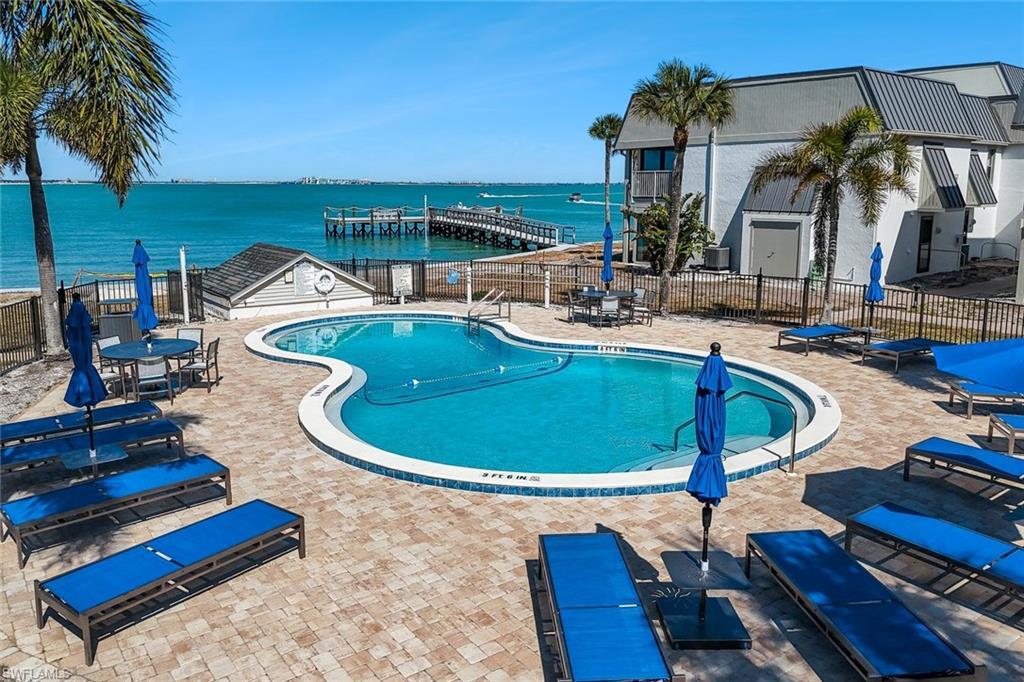 Image 3: Community pool featuring a patio and a water view
