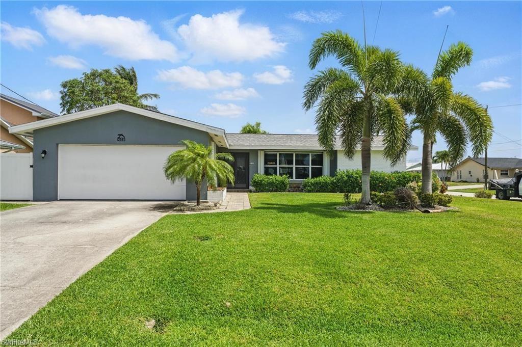 Image 2: Single story home featuring a garage, driveway, a front yard, and stucco siding