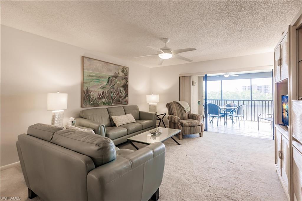 Image 4: Living area featuring light carpet, a textured ceiling, and ceiling fan