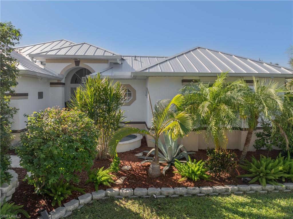 Image 3: Frontal view of home featuring stucco siding, a standing seam roof, and a metal roof