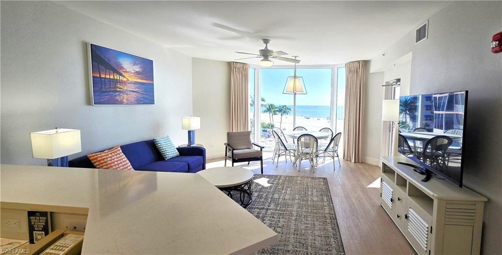 Image 3: Living room featuring floor to ceiling windows, wood finished floors, and a ceiling fan