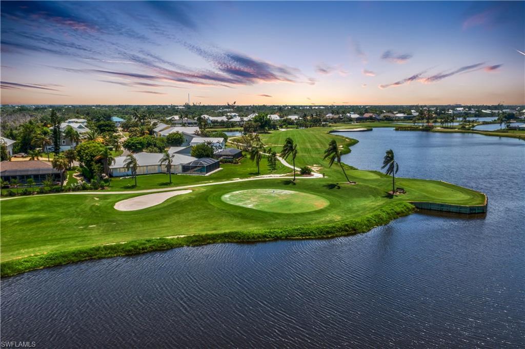 Image 1: Located on one of the best lots if not THE BEST lot in The Dunes! Almost half acre with panoramic views of the golf course and lakes!