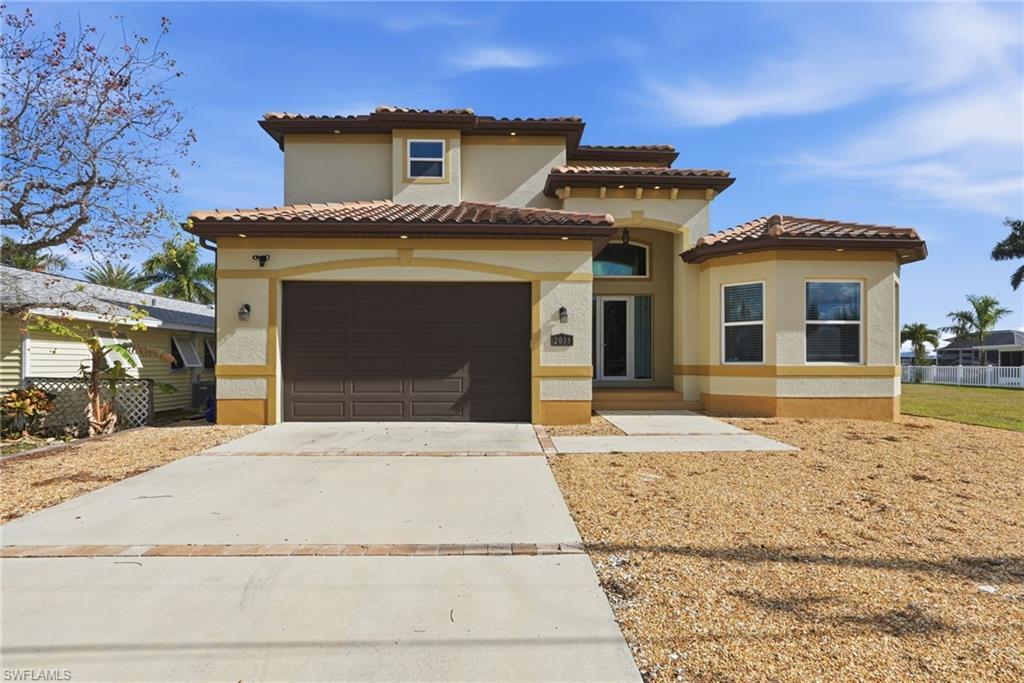Image 2: Mediterranean / spanish-style home featuring driveway, a garage, stucco siding, and a tile roof