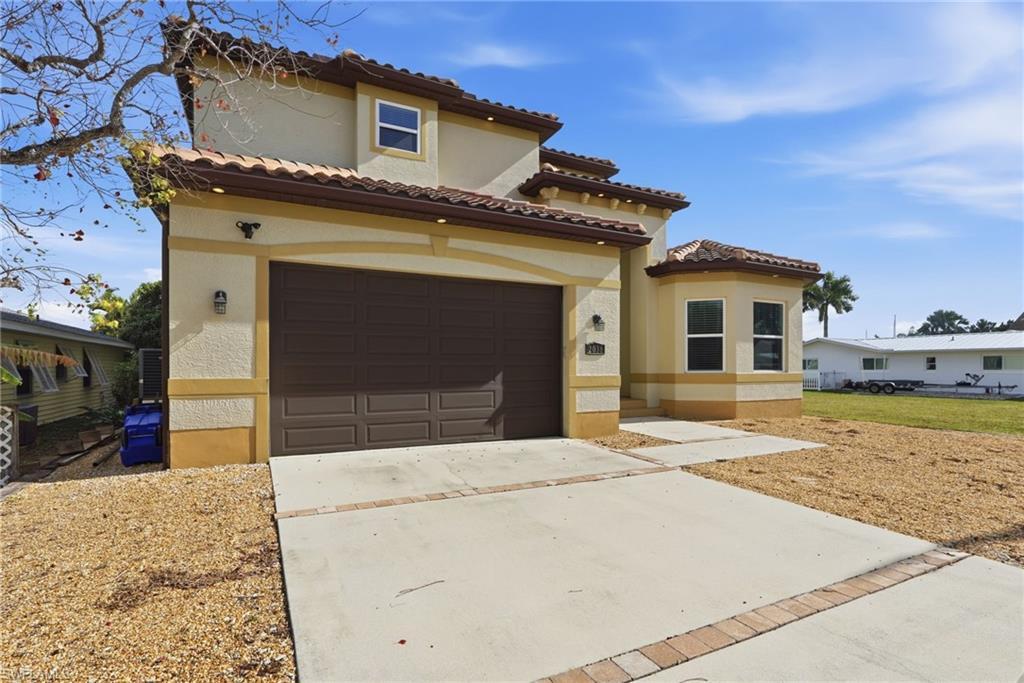 Image 3: Mediterranean / spanish-style house with concrete driveway, a garage, stucco siding, and a tile roof