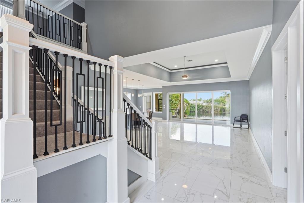 Image 4: Staircase with marble tiled floors, ornamental molding, recessed lighting, a raised ceiling, and decorative columns