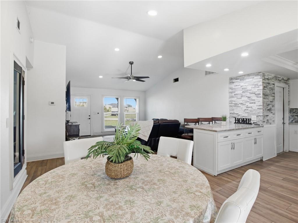 Image 4: Dining space featuring lofted ceiling, a ceiling fan, recessed lighting, and light wood-type flooring