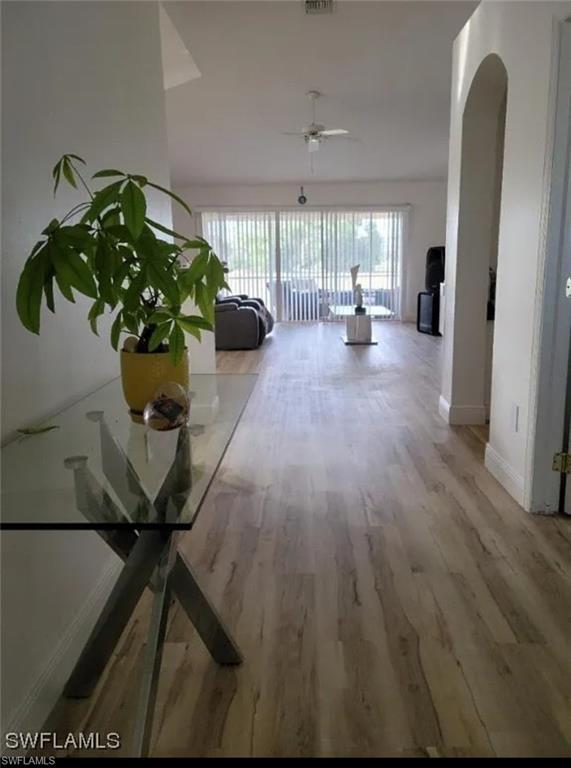 Image 2: Hall featuring light wood-style flooring and arched walkways