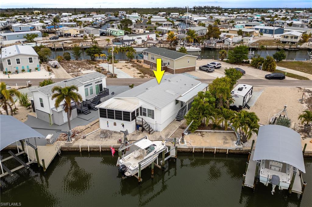 Image 1: Aerial view of rear of home on canal