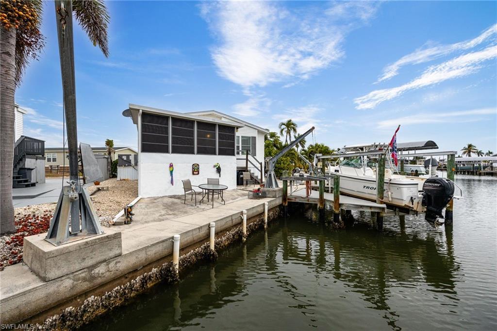 Image 4: Dock with boat lift, seawall, davits, a sunroom, and stairway