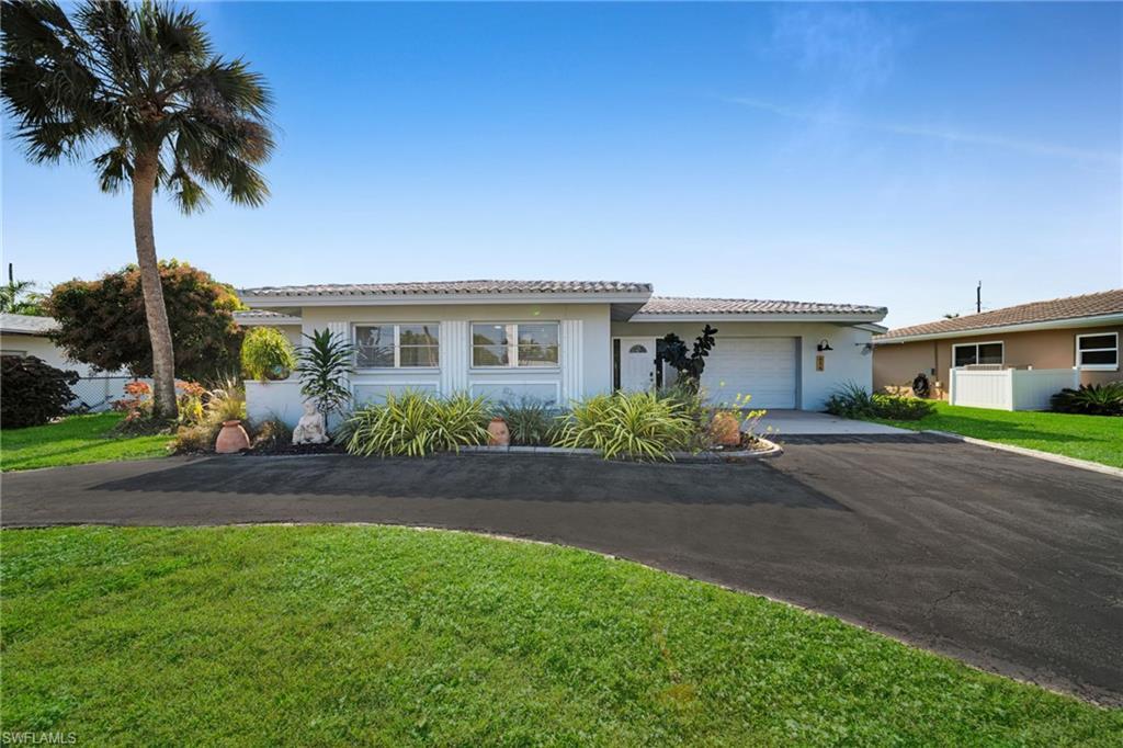 Image 1: Single story home with asphalt driveway, a front yard, a tile roof, and a garage