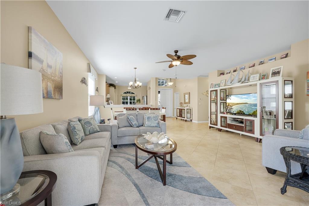 Image 3: Living area featuring a chandelier, ceiling fan, and light tile patterned floors