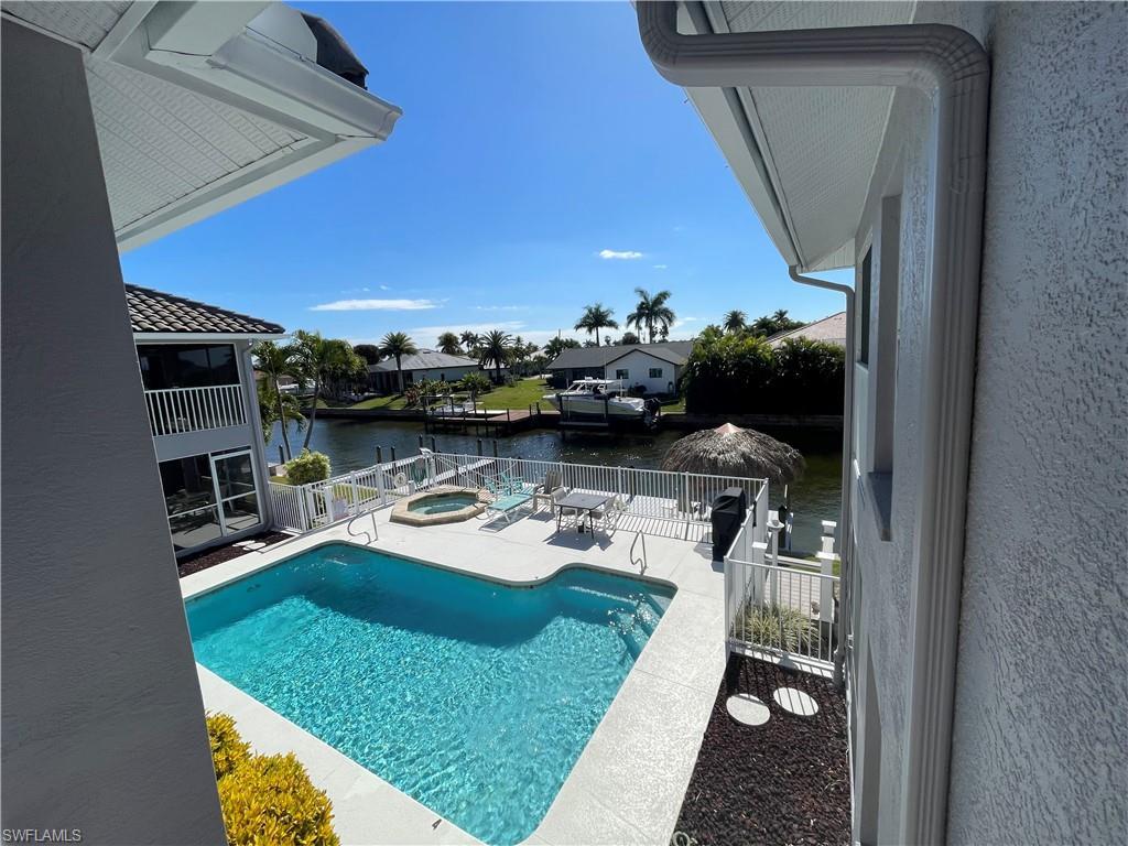 Image 3: View of pool with an in-ground hot tub, patio surround, and a water view
