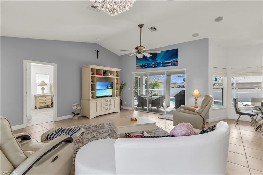 Image 4: Living area featuring lofted ceiling, light tile patterned floors, and ceiling fan