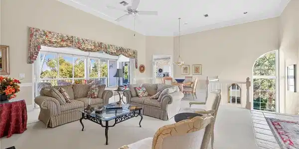 Image 3: Carpeted living room featuring a ceiling fan, crown molding, plenty of natural light, and a high ceiling
