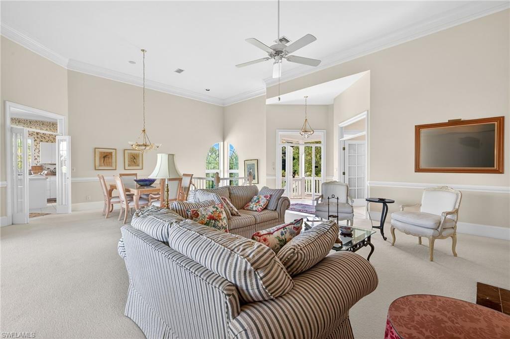 Image 4: Living area featuring crown molding, suspended lighting, carpet flooring, a ceiling fan, and a high ceiling