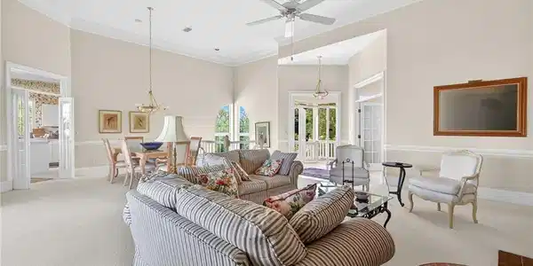 Image 4: Living area featuring crown molding, suspended lighting, carpet flooring, a ceiling fan, and a high ceiling