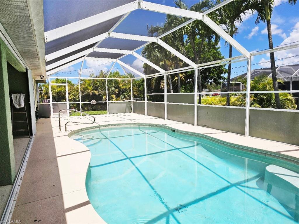 Image 3: Swimming pool featuring a patio, glass enclosure, and a sunroom