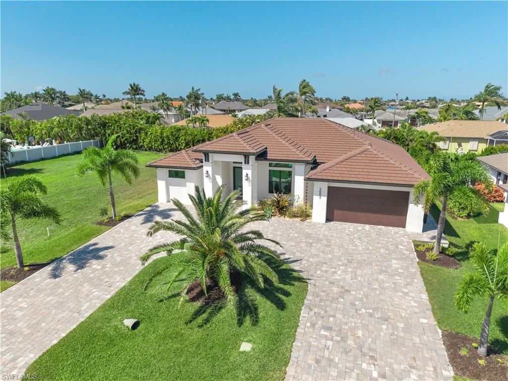 Image 1: Mediterranean / spanish-style home with an attached garage, a front lawn, stucco siding, driveway, and a residential view