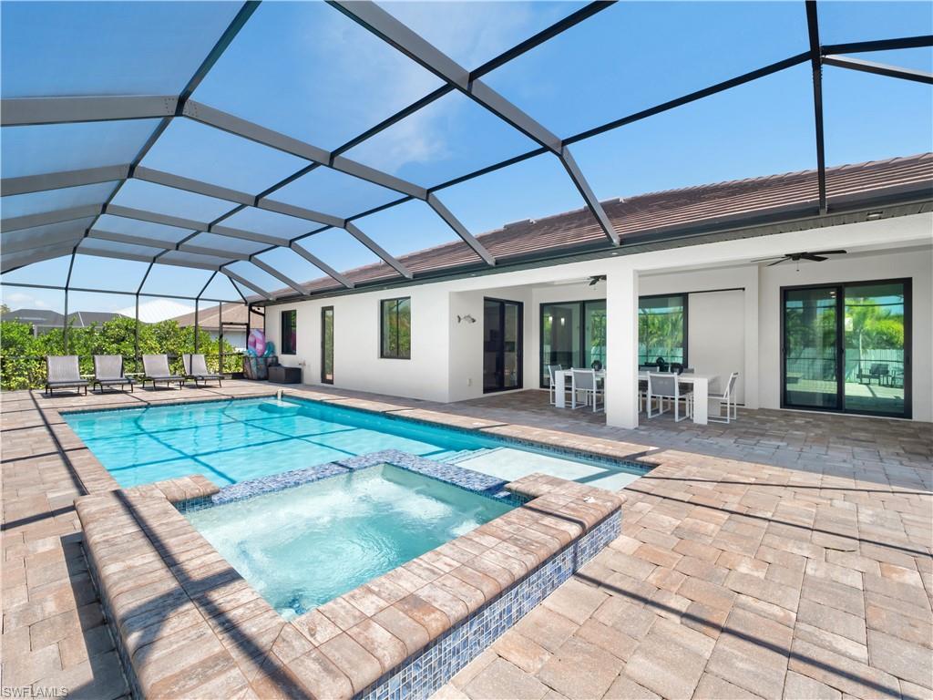 Image 4: Integrated pool / hot tub featuring a sunroom, a patio area, outdoor dining area, and a lanai