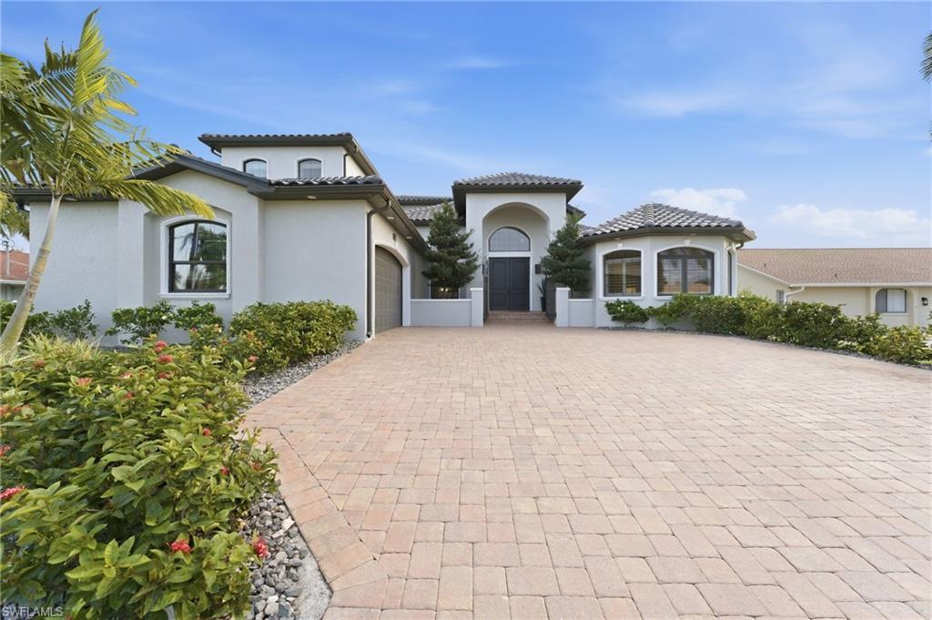 Image 2: Mediterranean / spanish-style home featuring an attached garage, stucco siding, driveway, and a tile roof