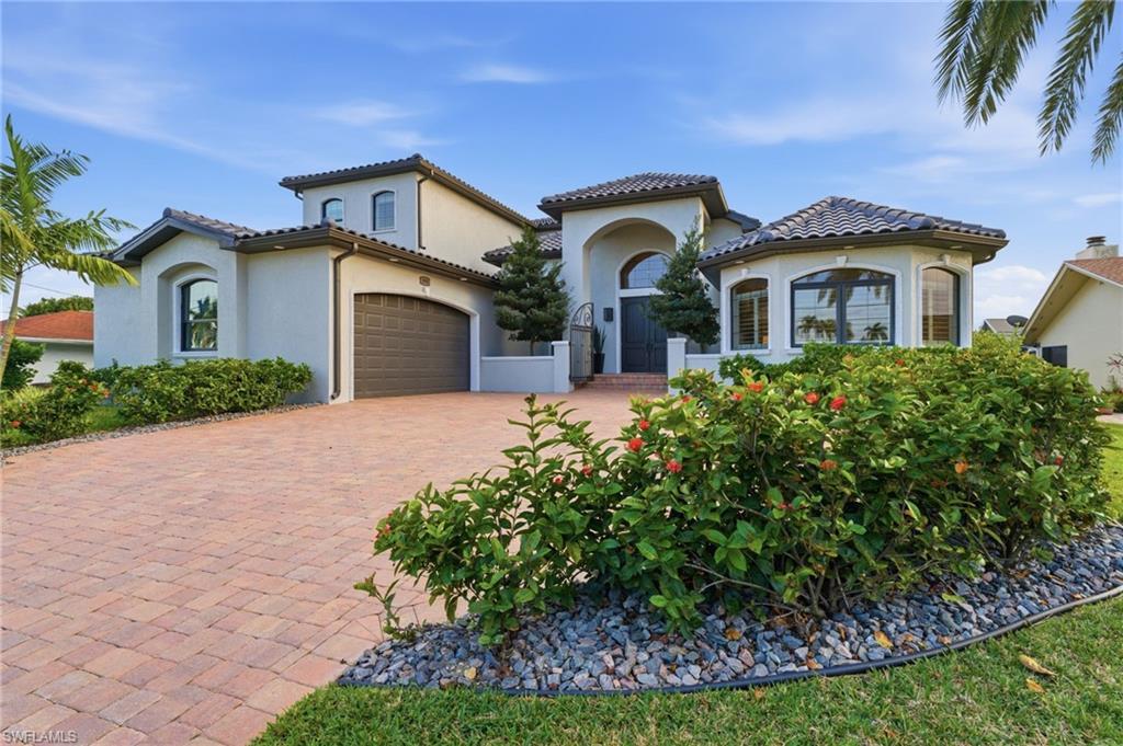 Image 3: Mediterranean / spanish house with stucco siding, decorative driveway, a garage, and a tiled roof