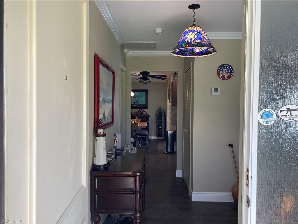 Image 2: Hall with ornamental molding and dark wood finished floors