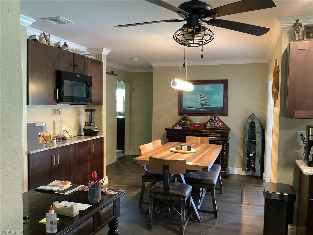 Image 3: Dining area with crown molding, dark wood finished floors, and a ceiling fan