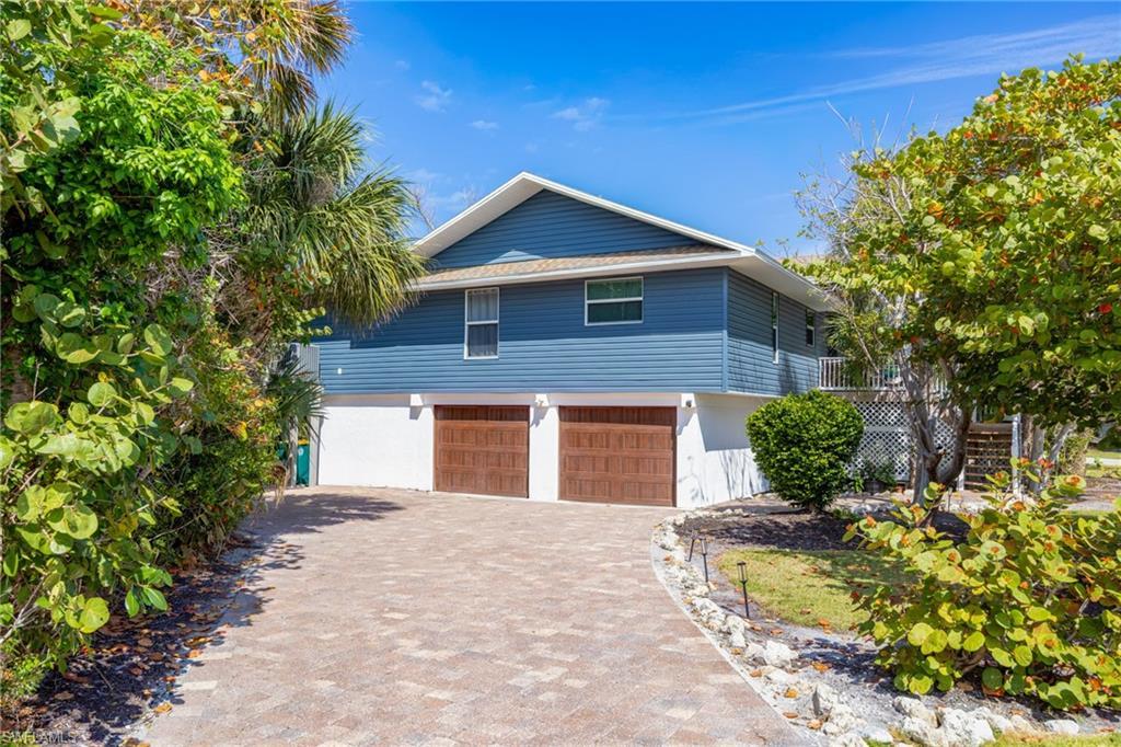 Image 1: View of front of property featuring decorative driveway and an attached garage