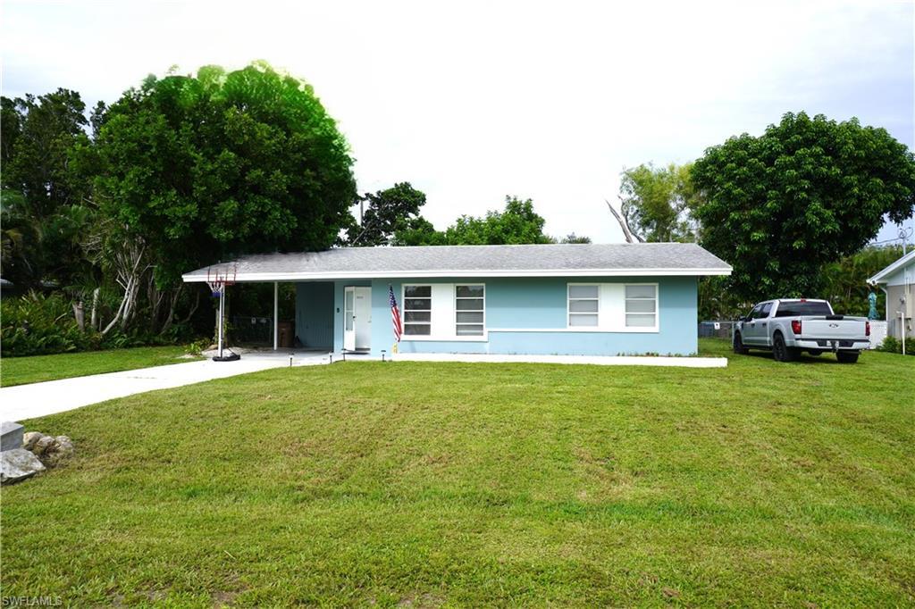 Image 1: Ranch-style home with a carport, a front yard, and concrete driveway